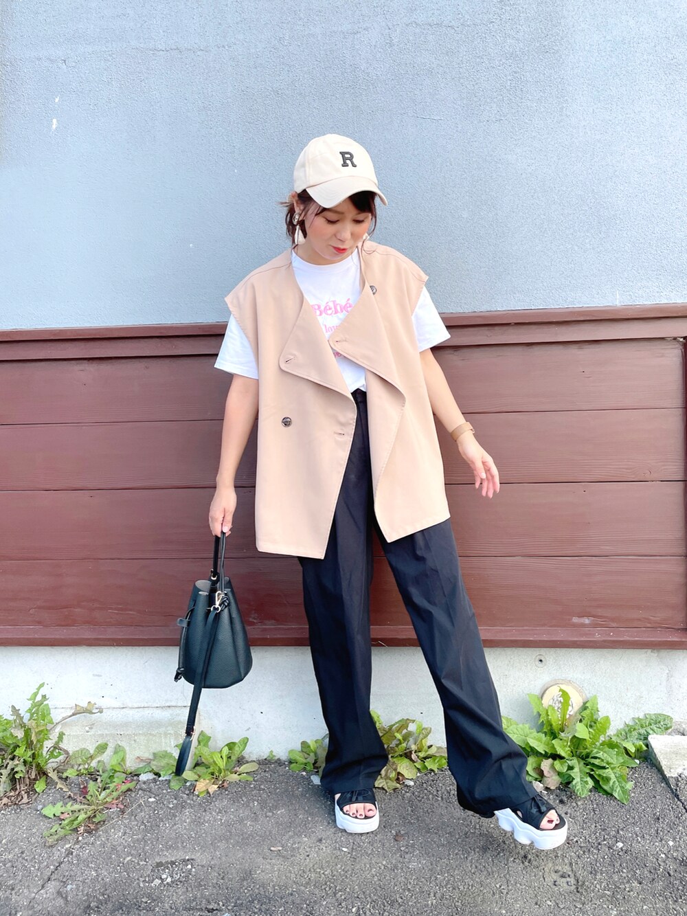 ホワイト系のTシャツ/カットソー、ベージュ系のベスト、ブラック系のスーツセットを着用したレディースの秋コーディネートの4枚目の写真