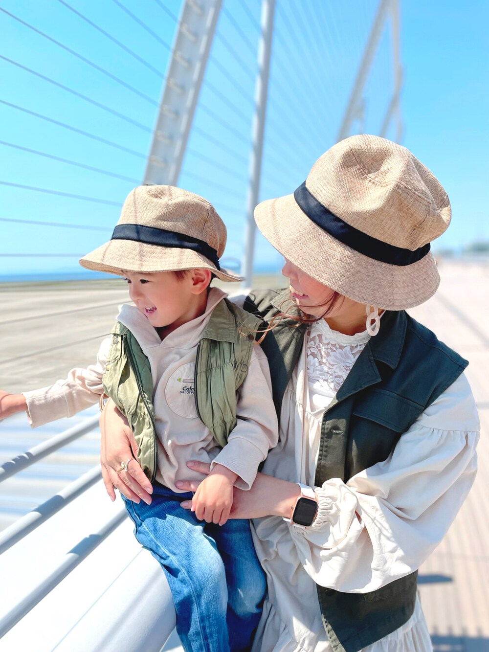 グリーン系のベスト、ホワイト系のタンクトップ、ホワイト系のワンピースを着用したレディースの春コーディネートの5枚目の写真