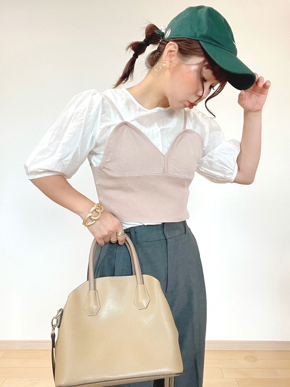 グレー系のパンツ、ブラウン系のキャミソール、ホワイト系のスニーカーを着用したレディースの秋コーディネートの4枚目の写真