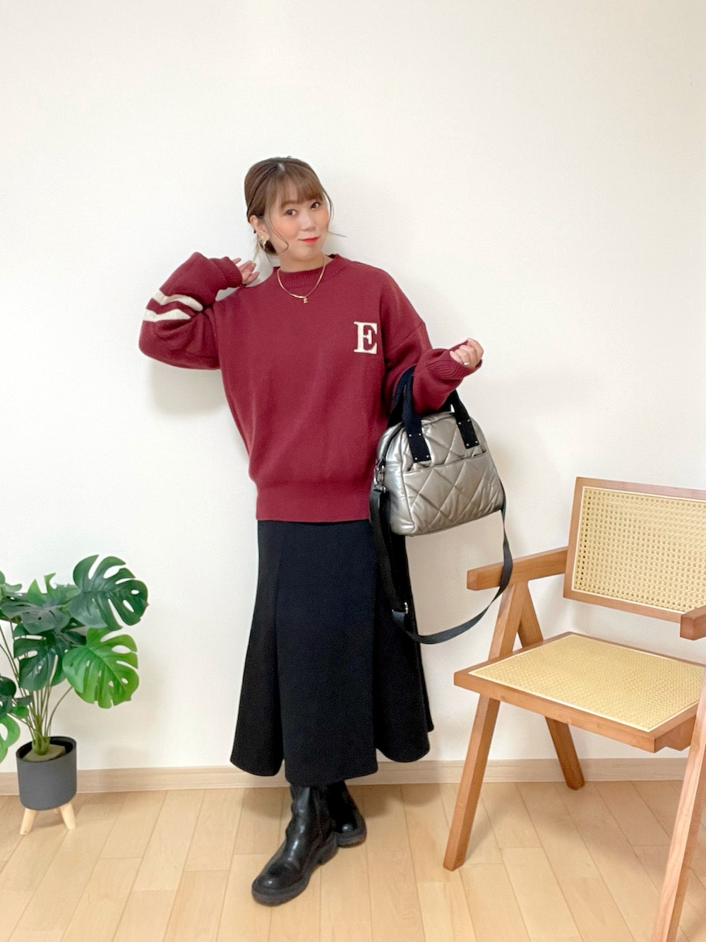 レッド系のニット/セーター、ブラック系のスカート、シルバー系のトートバッグを着用したレディースの冬コーディネートの4枚目の写真