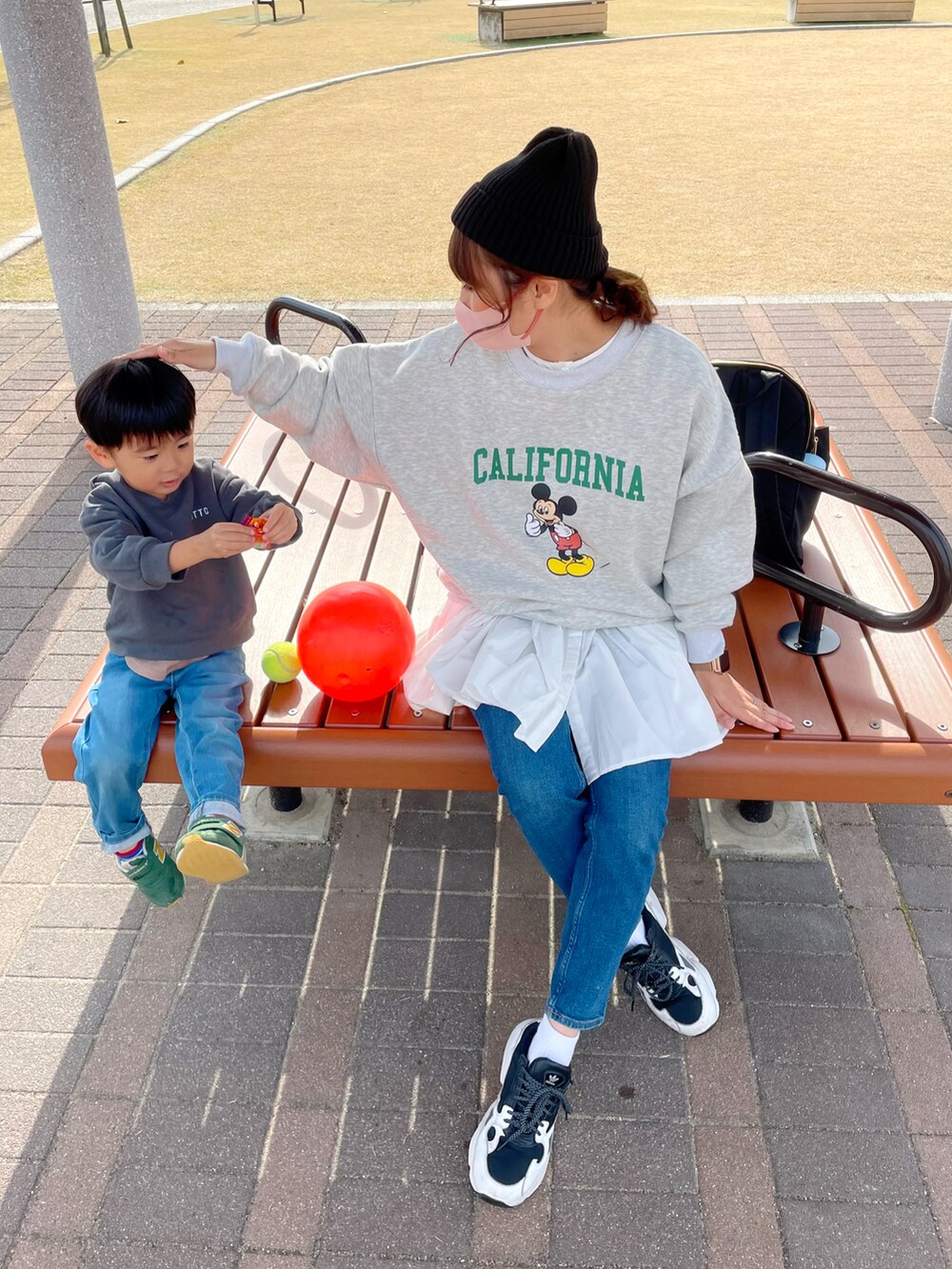 グレー系のスウェット、ホワイト系のシャツ/ブラウス、ブルー系のデニムパンツを着用したレディースの秋コーディネートの2枚目の写真