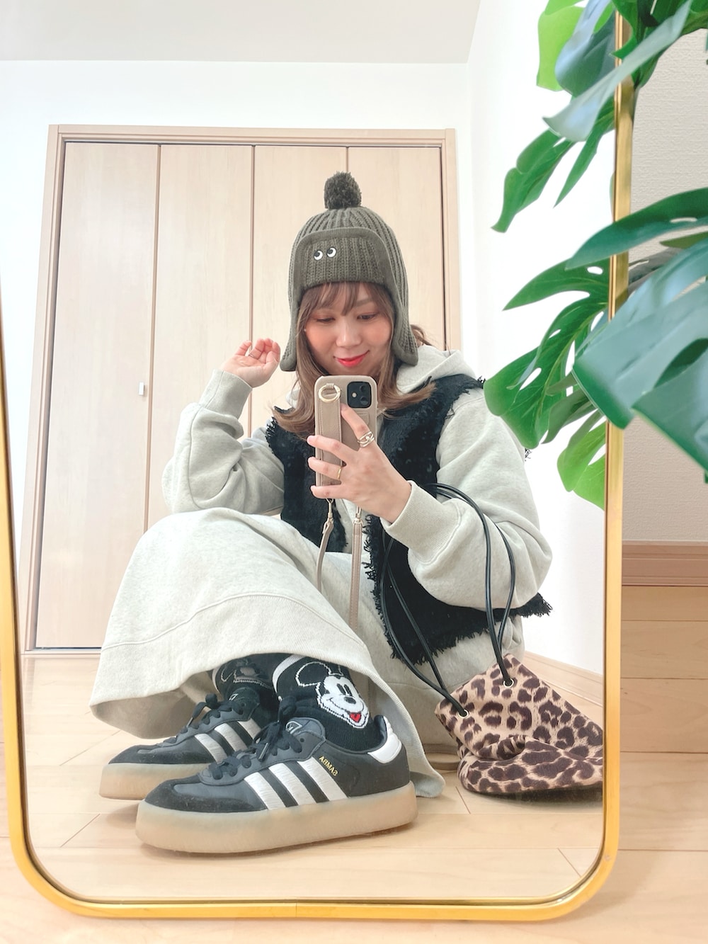 ベージュ系のワンピース、ブラック系のスニーカー、その他のハンドバッグを着用したレディースの冬コーディネートの2枚目の写真