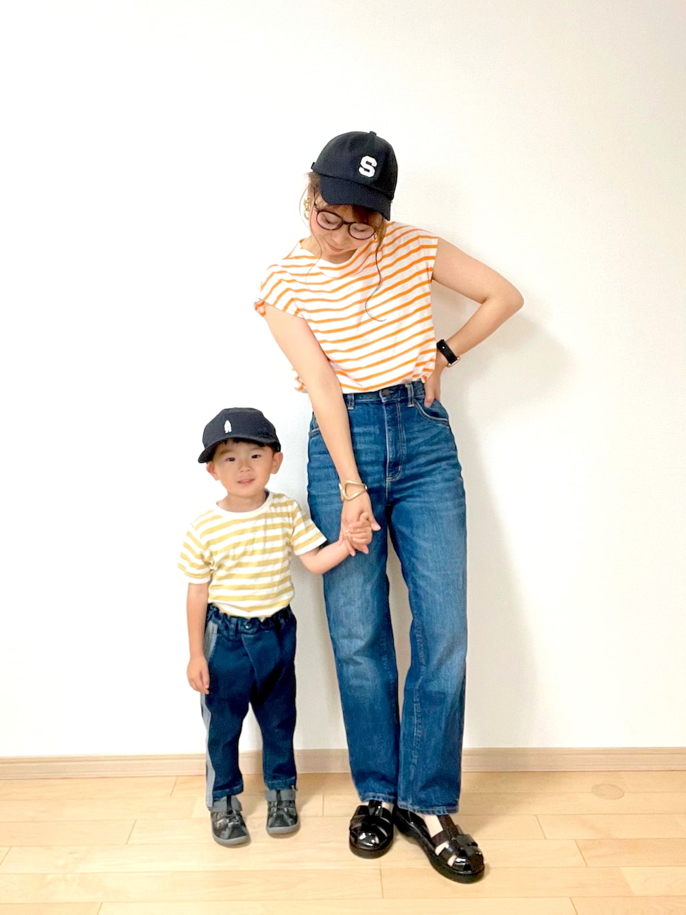 オレンジ系のTシャツ/カットソー、ブルー系のデニムパンツ、ブラック系のサンダルを着用したレディースの夏コーディネートの2枚目の写真