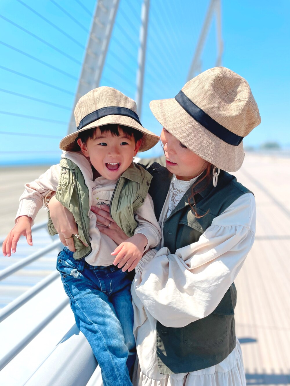 グリーン系のベスト、ホワイト系のタンクトップ、ホワイト系のワンピースを着用したレディースの春コーディネートの3枚目の写真