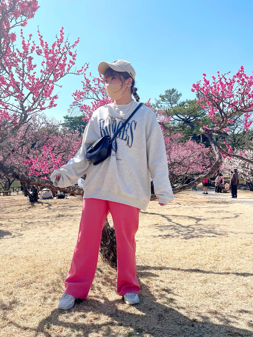 ベージュ系のスウェット、ホワイト系のジャケット/アウター、ピンク系のスラックスを着用したレディースの春コーディネートの4枚目の写真