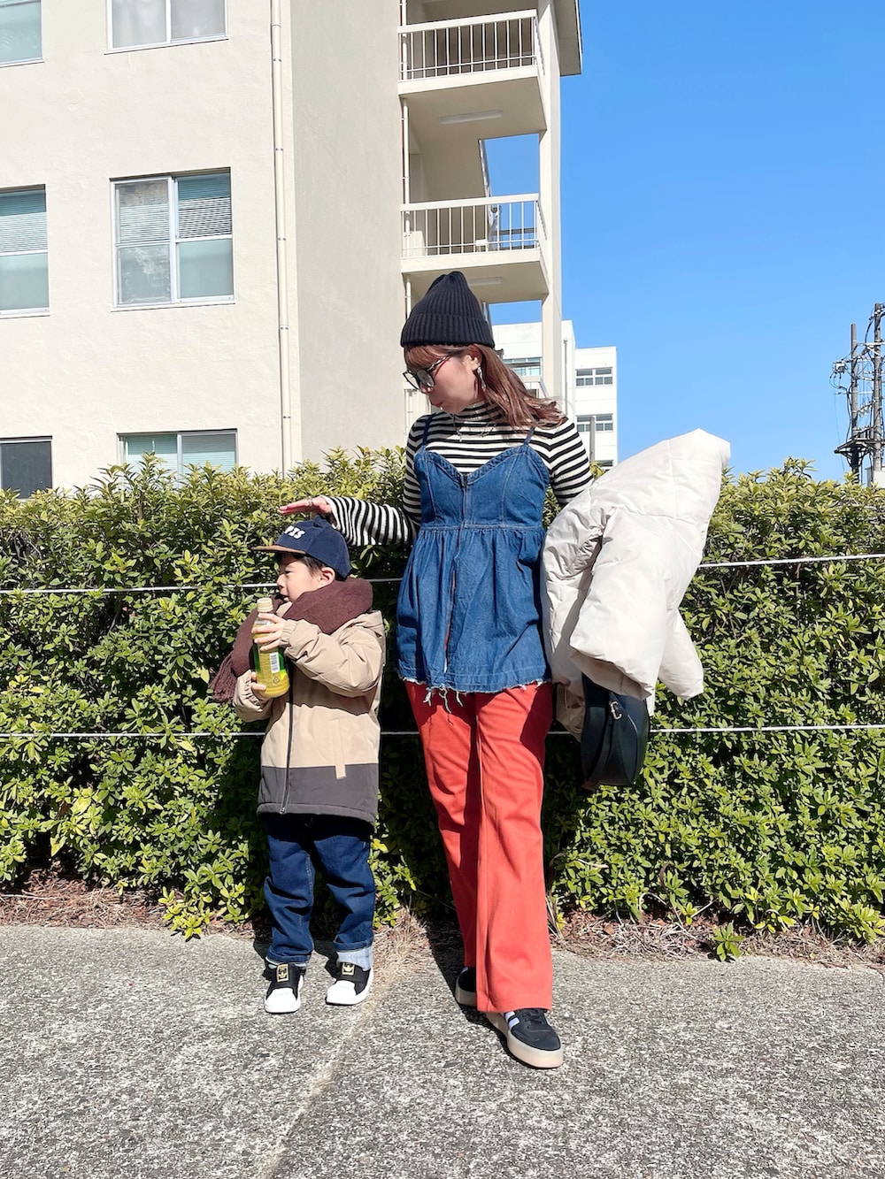 ホワイト系のジャケット/アウター、ブラック系のニット/セーター、ブルー系のキャミソールを着用したレディースの春コーディネートの2枚目の写真