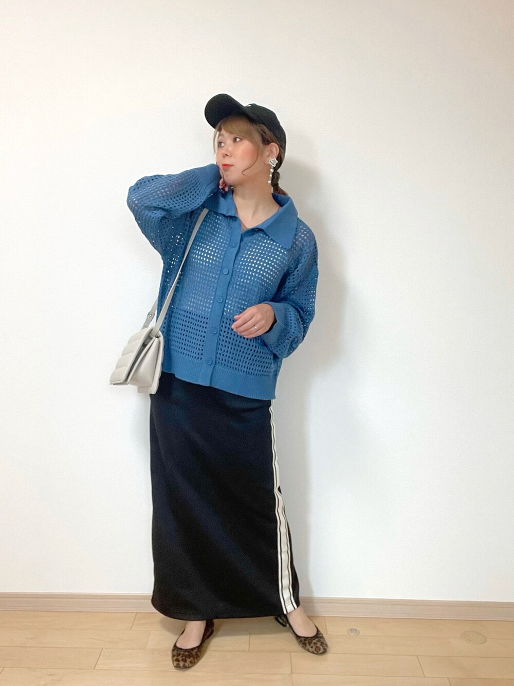 ホワイト系のタンクトップ、ブルー系のカーディガン/ボレロ、ブラック系のスカートを着用したレディースの秋コーディネートの4枚目の写真