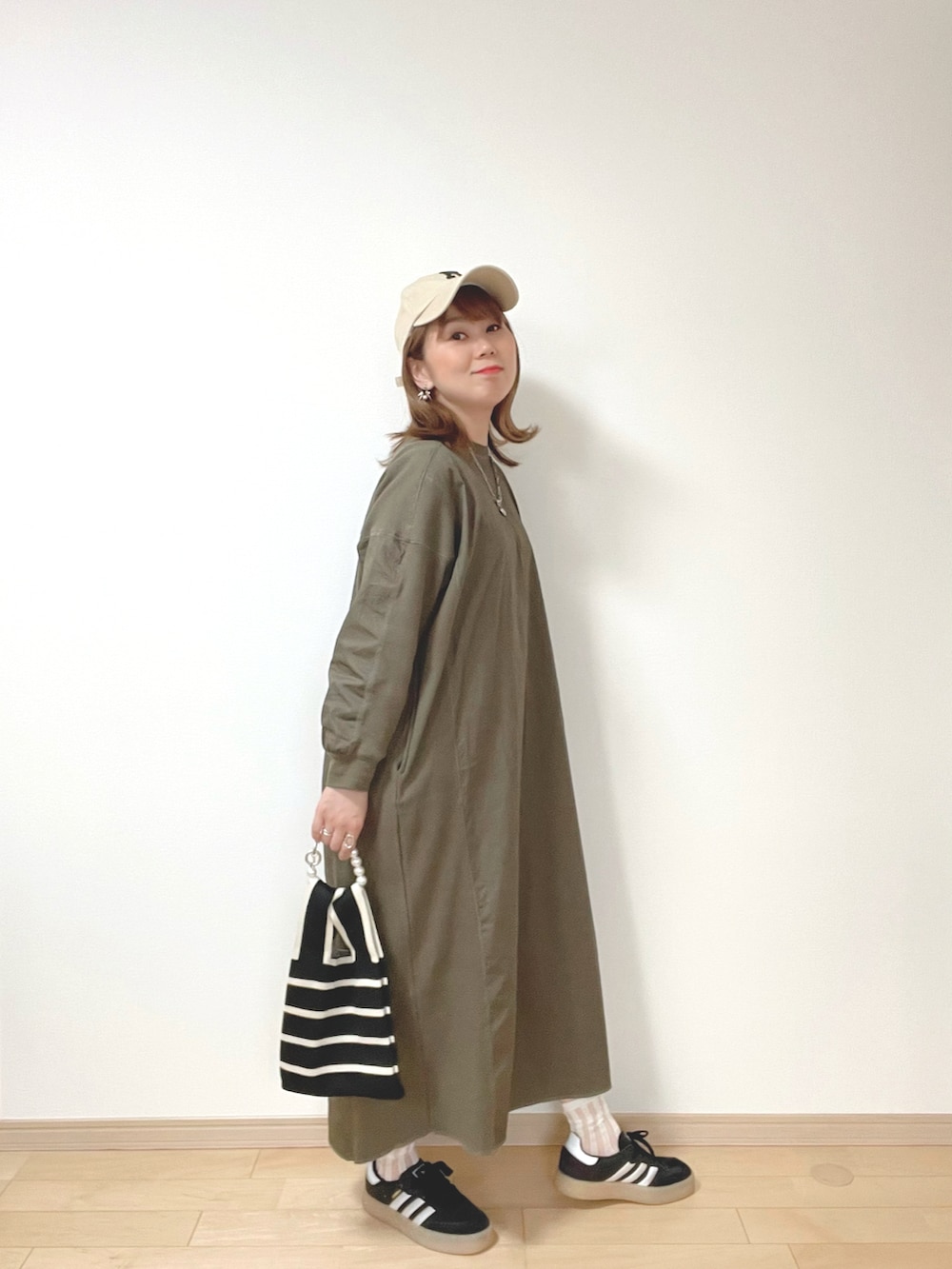 グレー系のキャミソール、グリーン系のワンピース、ブラック系のサンダルを着用したレディースの春コーディネートの4枚目の写真