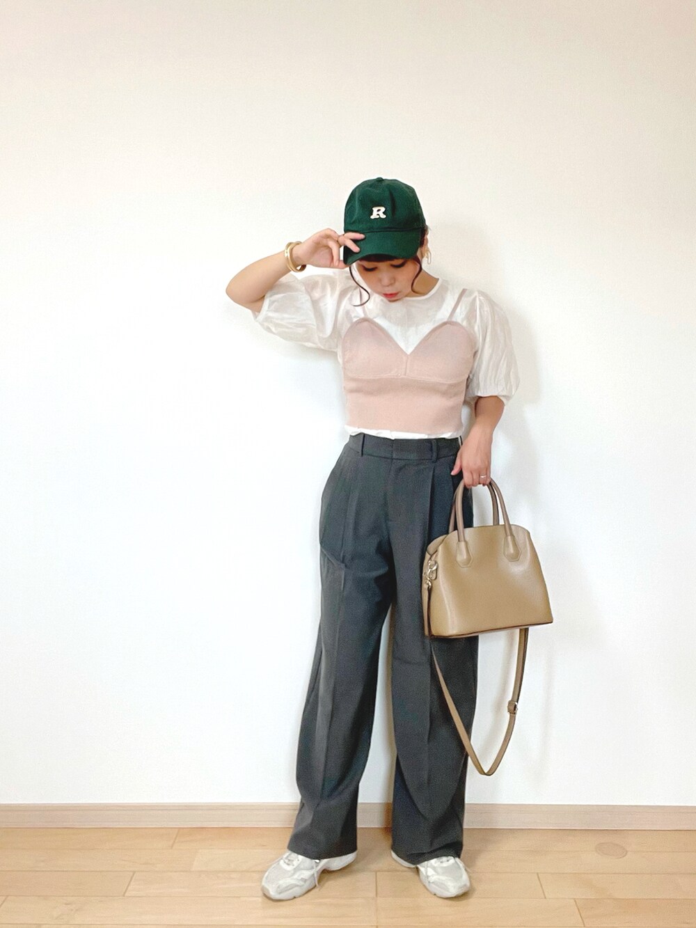 グレー系のパンツ、ブラウン系のキャミソール、ホワイト系のスニーカーを着用したレディースの秋コーディネートの2枚目の写真