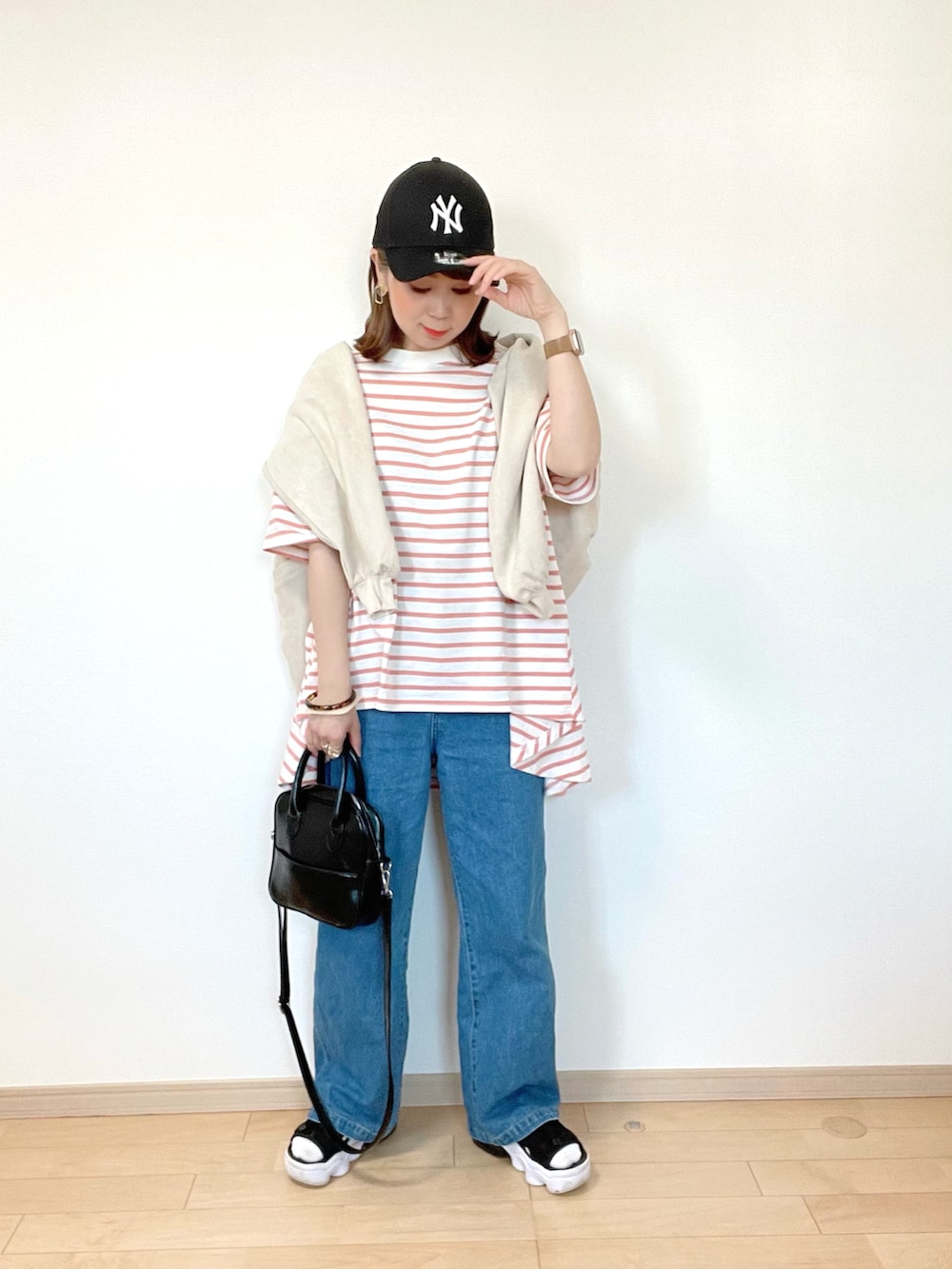 ピンク系のTシャツ/カットソー、ブルー系のデニムパンツ、ブラック系のサンダルを着用したレディースの春コーディネートの3枚目の写真