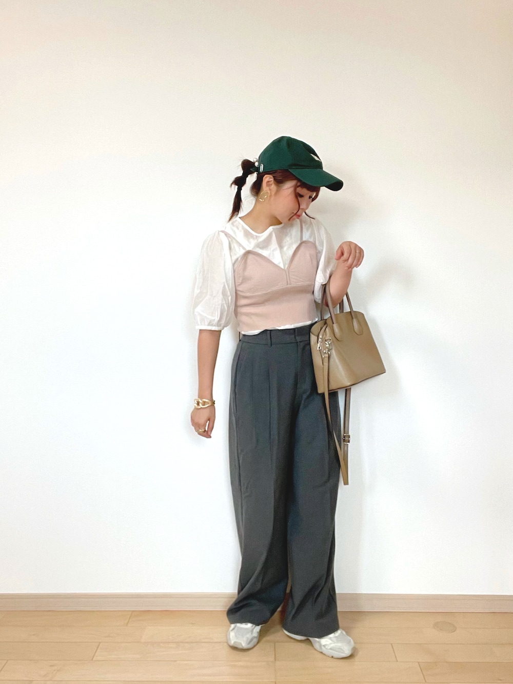 グレー系のパンツ、ブラウン系のキャミソール、ホワイト系のスニーカーを着用したレディースの秋コーディネートの3枚目の写真