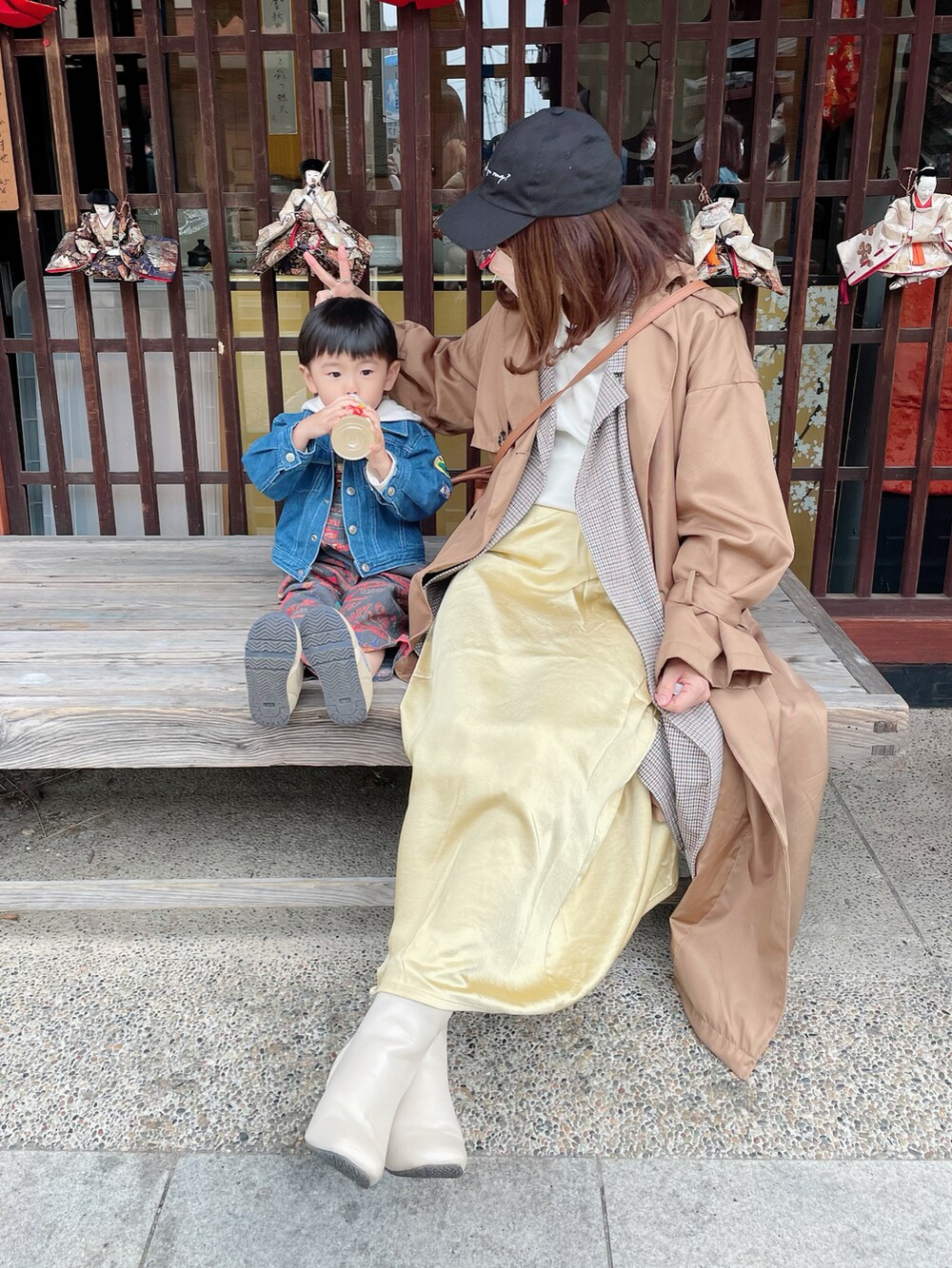 ベージュ系のトレンチコート、イエロー系のスカート、ホワイト系のスウェットを着用したレディースの春コーディネートの2枚目の写真