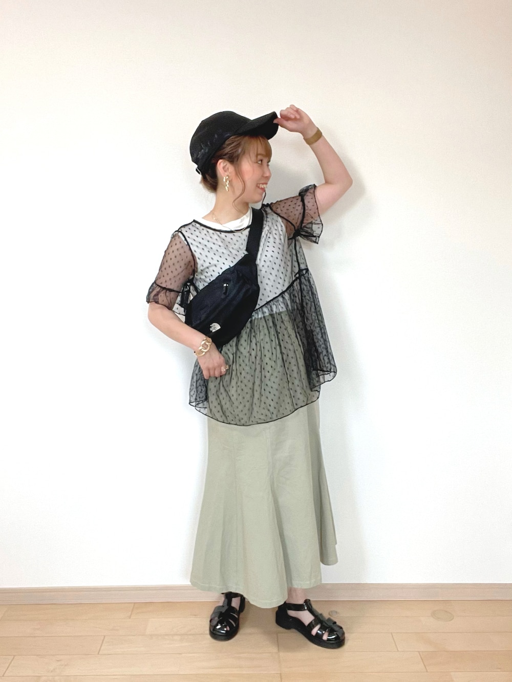 ホワイト系のTシャツ/カットソー、ブラック系のトップス、グリーン系のスカートを着用したレディースの夏コーディネートの2枚目の写真