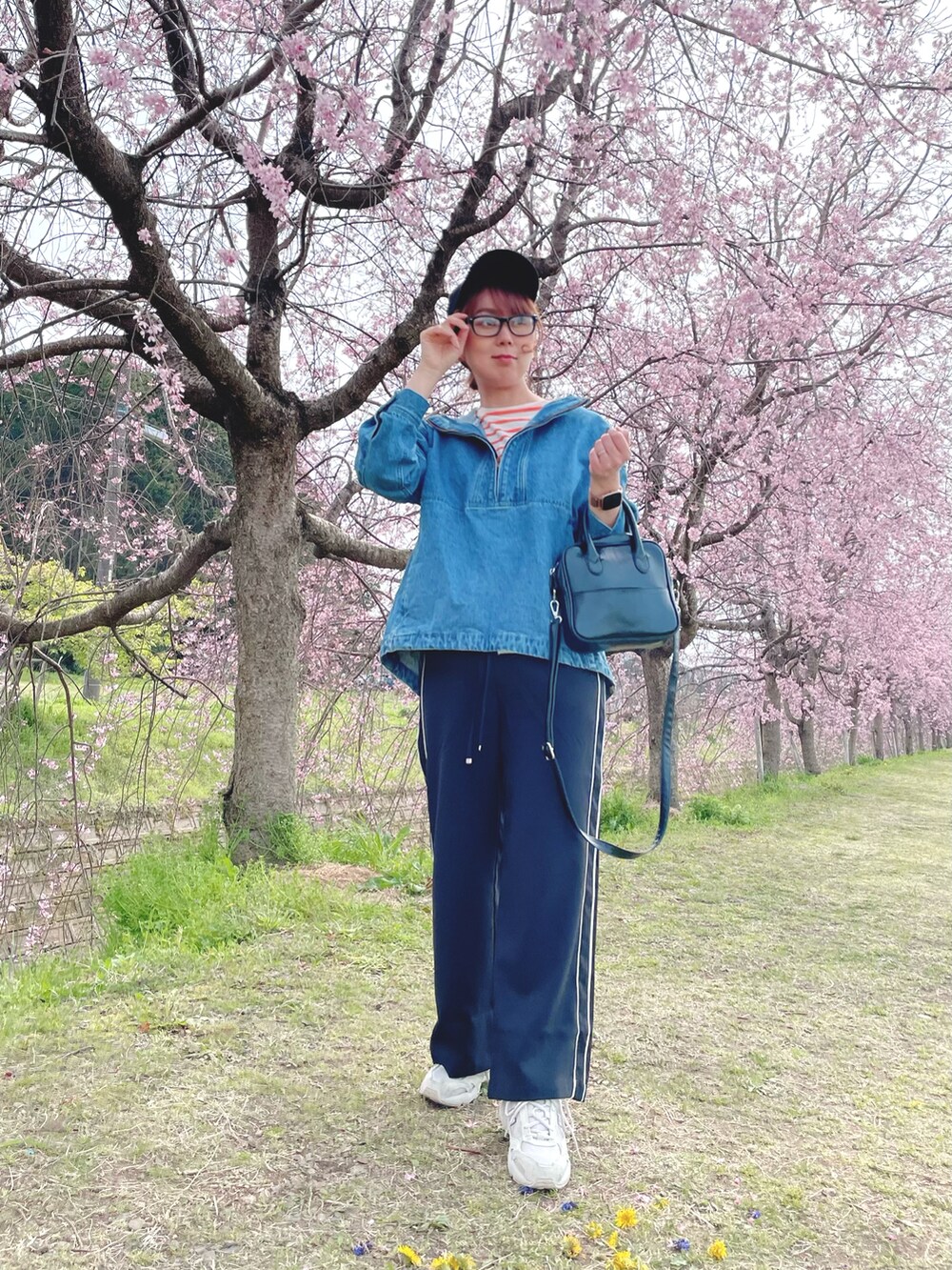 ブラック系のその他パンツ、ブルー系のトップス、オレンジ系のTシャツ/カットソーを着用したレディースの春コーディネートの3枚目の写真