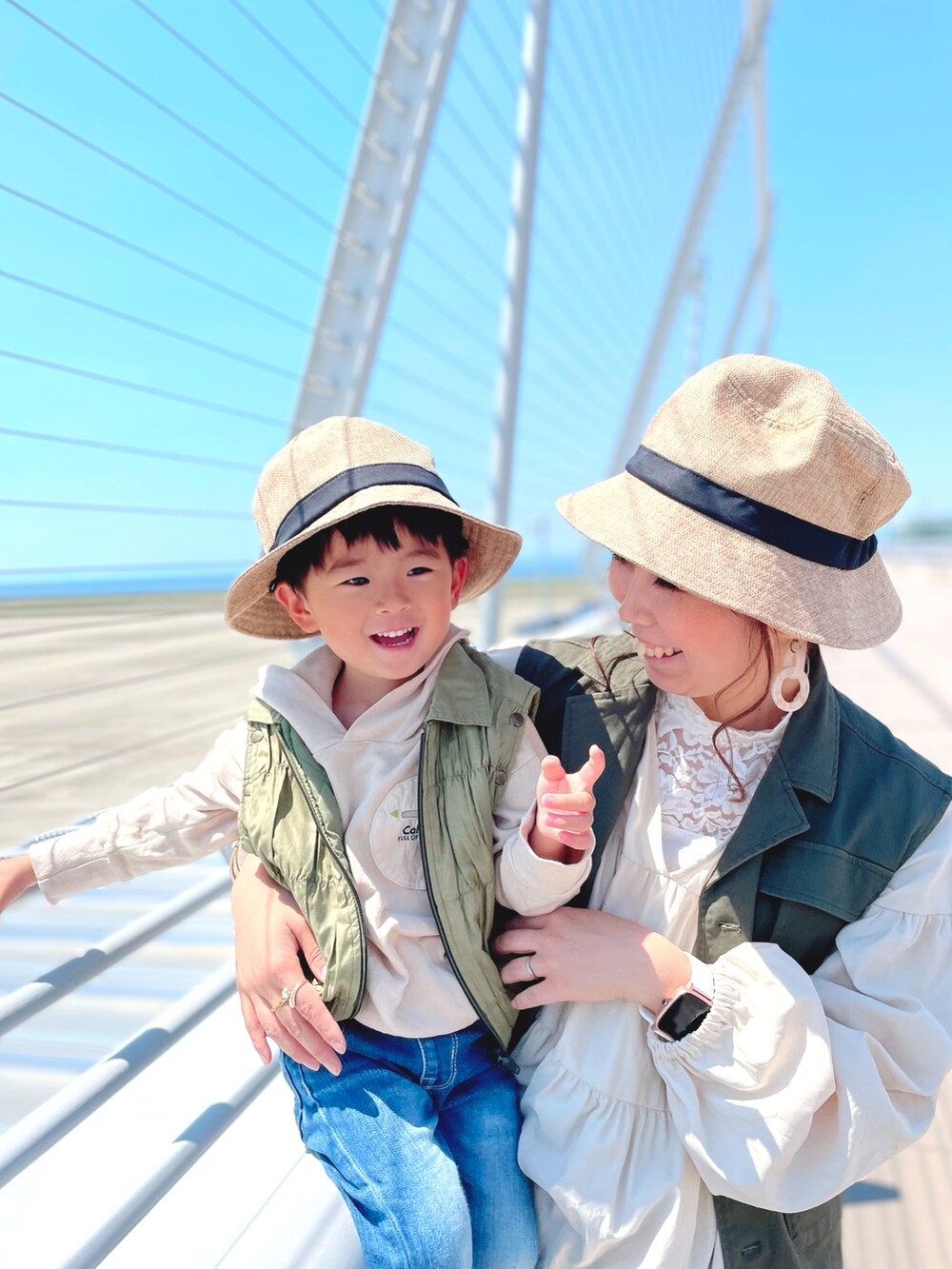 グリーン系のベスト、ホワイト系のタンクトップ、ホワイト系のワンピースを着用したレディースの春コーディネートの4枚目の写真