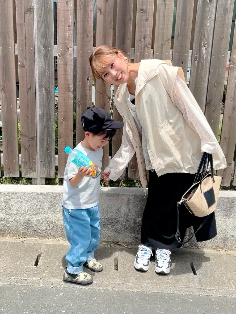 ホワイト系のブルゾン、ブラック系のワンピース、ホワイト系のタンクトップを着用したレディースの春コーディネートの3枚目の写真