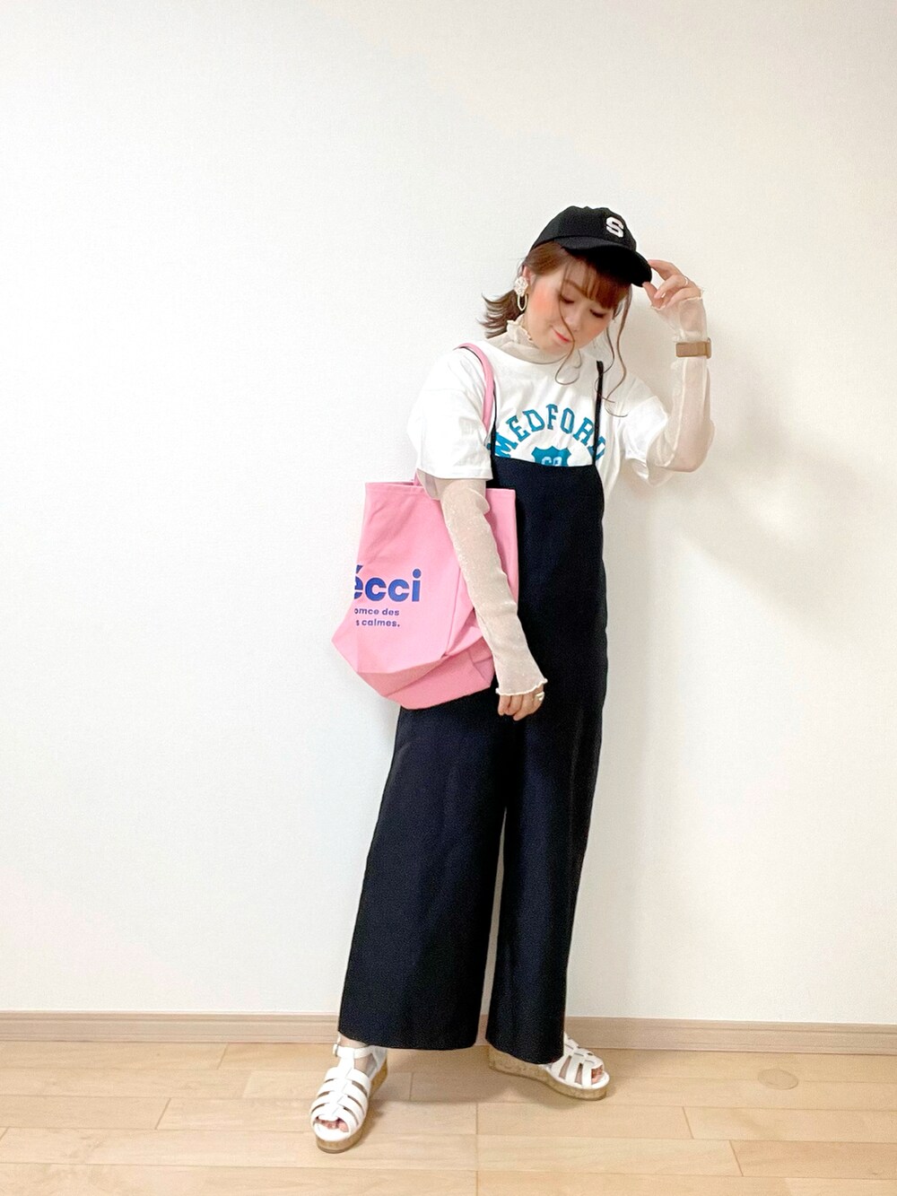 ホワイト系のTシャツ/カットソー、ベージュ系のトップス、ブラック系のサロペット/オーバーオールを着用したレディースの春コーディネートの2枚目の写真