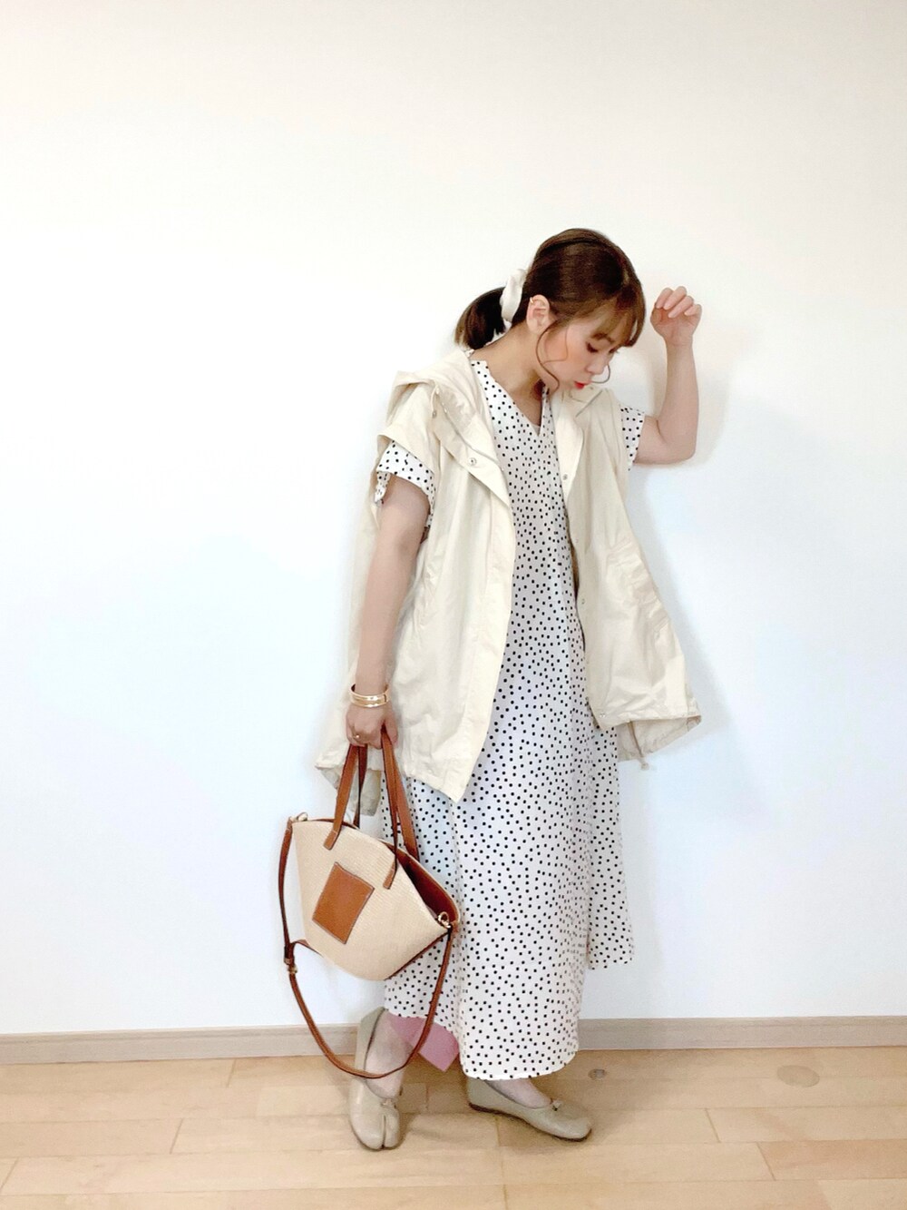 ホワイト系のブルゾン、ベージュ系のタンクトップ、ホワイト系のワンピースを着用したレディースの春コーディネートの2枚目の写真