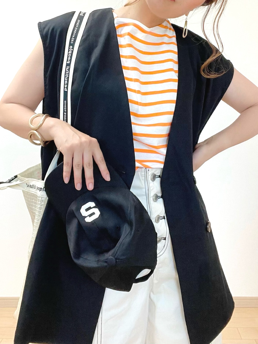 ブラック系のスーツセット、オレンジ系のTシャツ/カットソー、ホワイト系のその他パンツを着用したレディースの春コーディネートの3枚目の写真