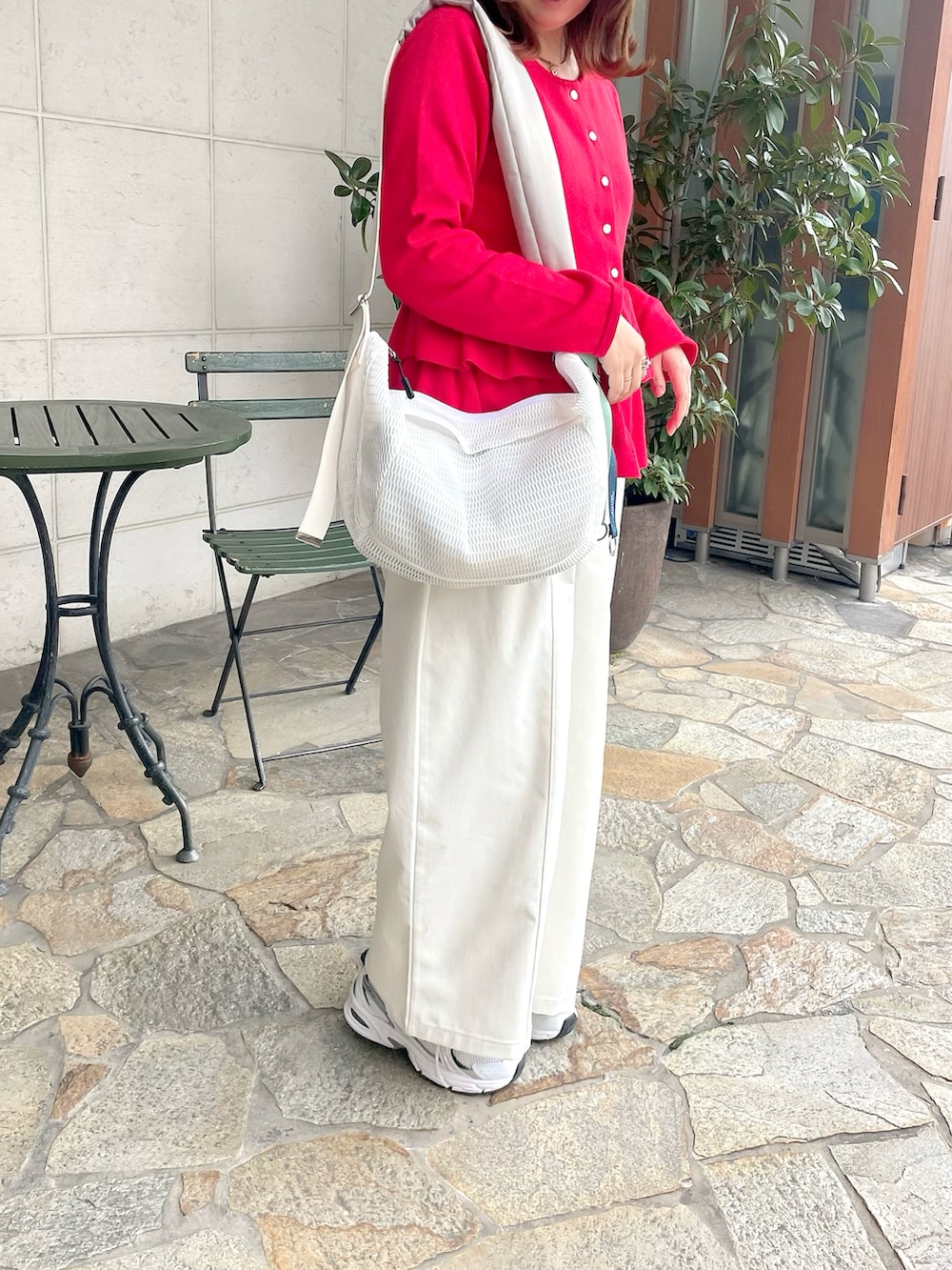 ホワイト系のボディバッグ/ウエストポーチ、ブラック系のブルゾン、レッド系のニット/セーターを着用したレディースの春コーディネートの4枚目の写真