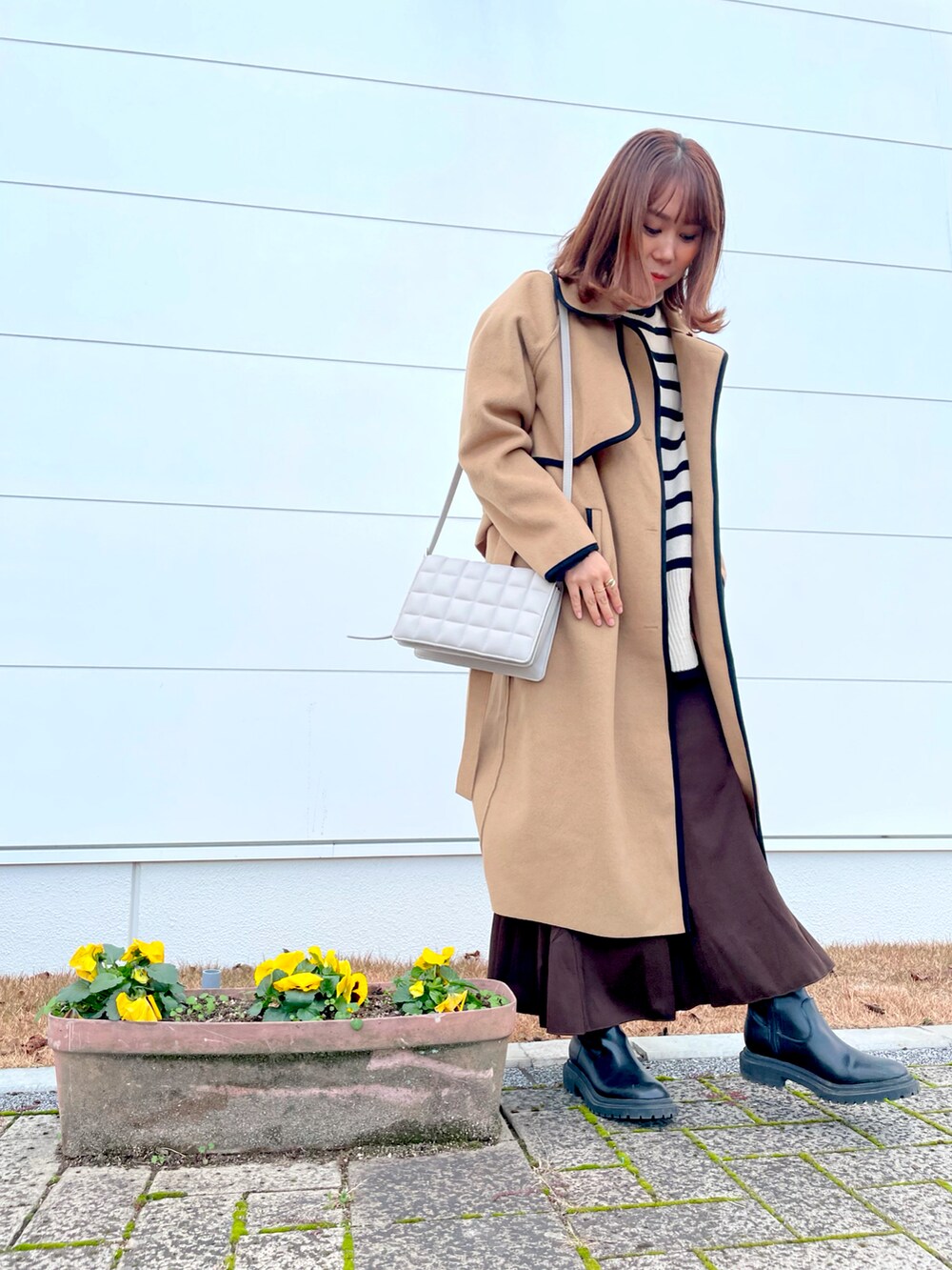 ブラウン系のスカート、ベージュ系のニット/セーター、ベージュ系のジャケット/アウターを着用したレディースの冬コーディネートの2枚目の写真