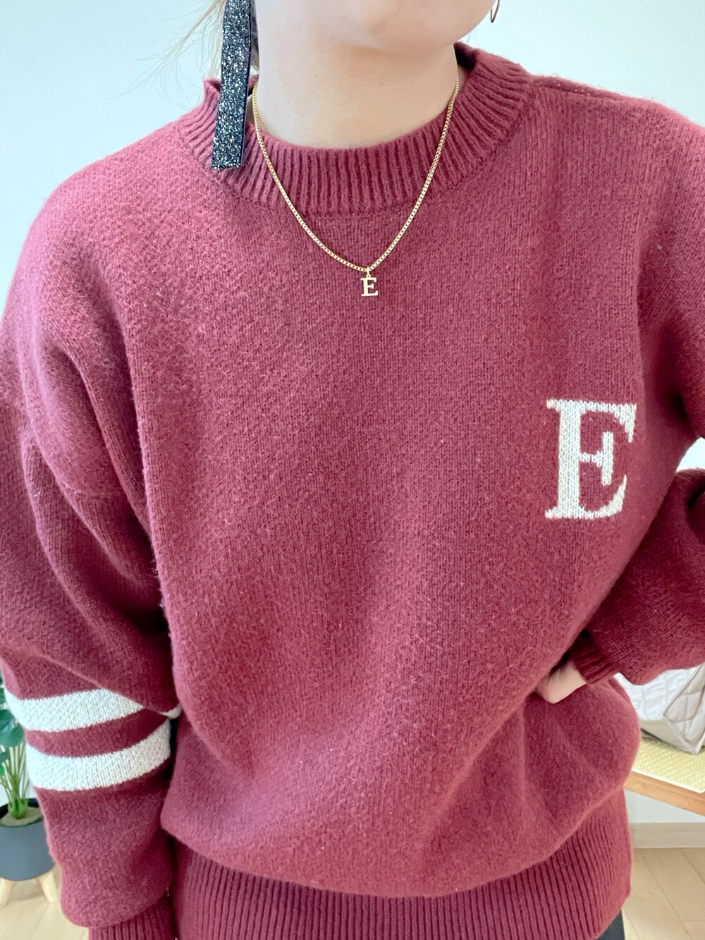 レッド系のニット/セーター、ブラック系のスカート、シルバー系のトートバッグを着用したレディースの冬コーディネートの5枚目の写真