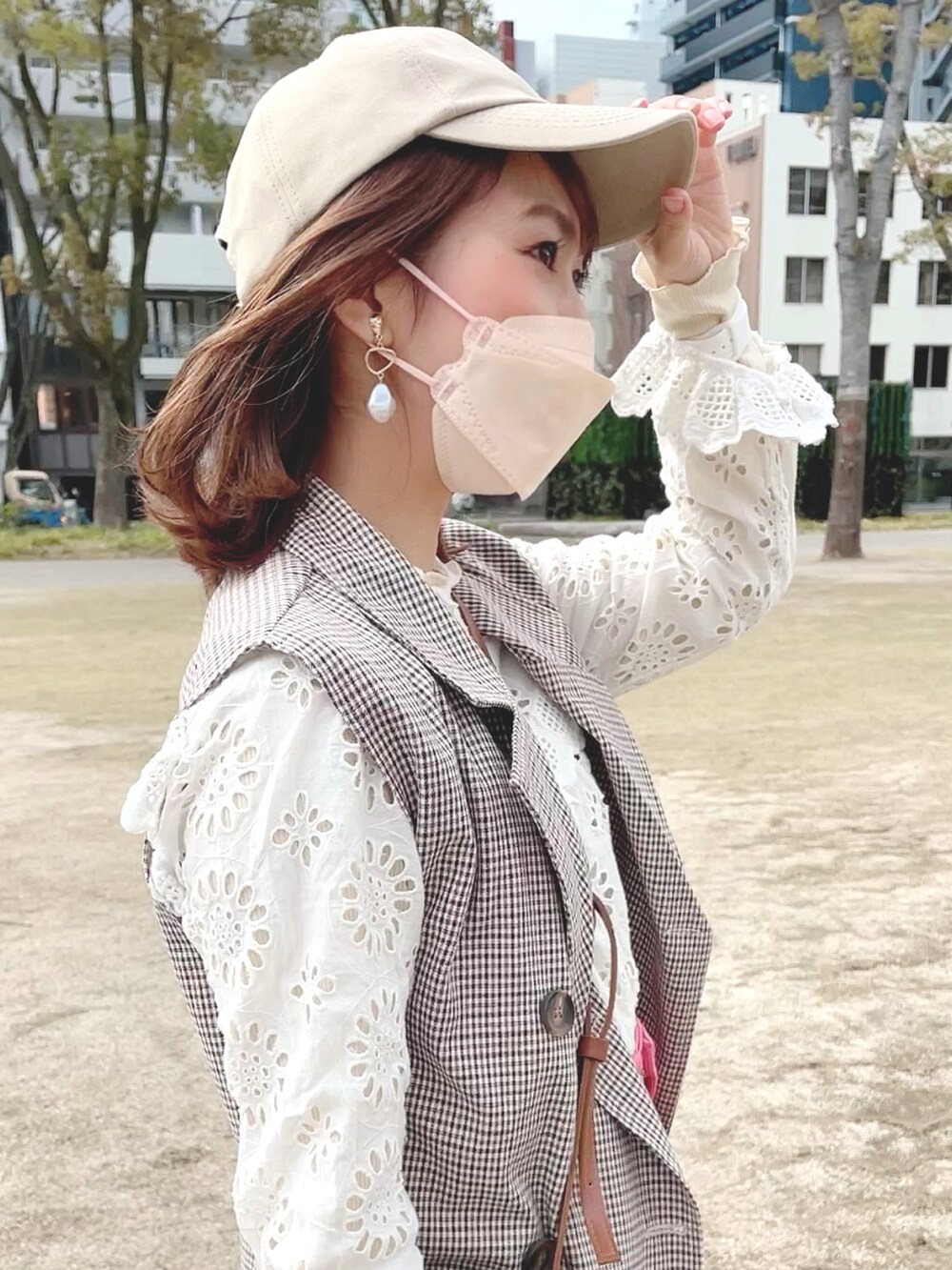 ピンク系のスラックス、ホワイト系のシャツ/ブラウス、ベージュ系のトレンチコートを着用したレディースの春コーディネートの3枚目の写真