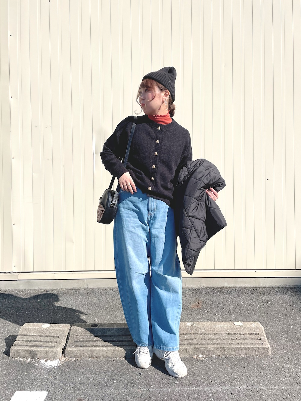 オレンジ系のトップス、ブラック系のカーディガン/ボレロ、ブラック系のジャケット/アウターを着用したレディースの冬コーディネートの2枚目の写真