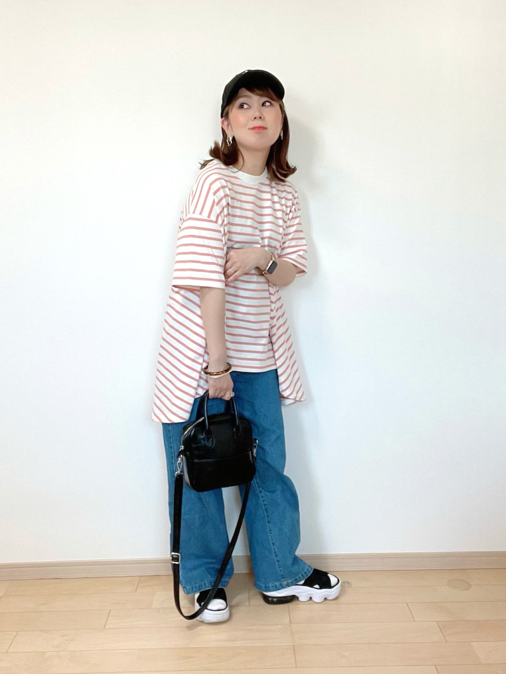 ピンク系のTシャツ/カットソー、ブルー系のデニムパンツ、ブラック系のサンダルを着用したレディースの春コーディネートの4枚目の写真