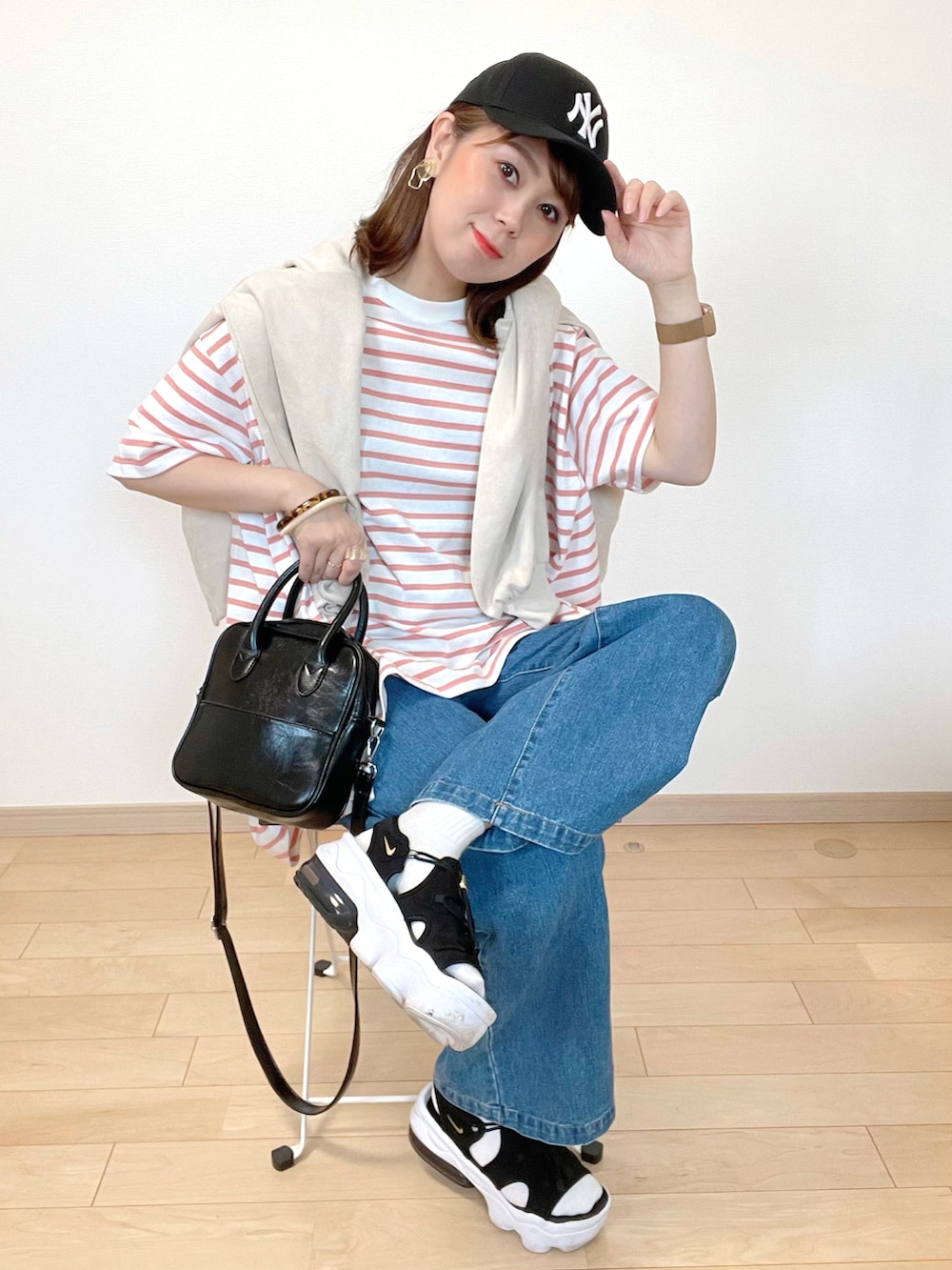 ピンク系のTシャツ/カットソー、ブルー系のデニムパンツ、ブラック系のサンダルを着用したレディースの春コーディネートの2枚目の写真