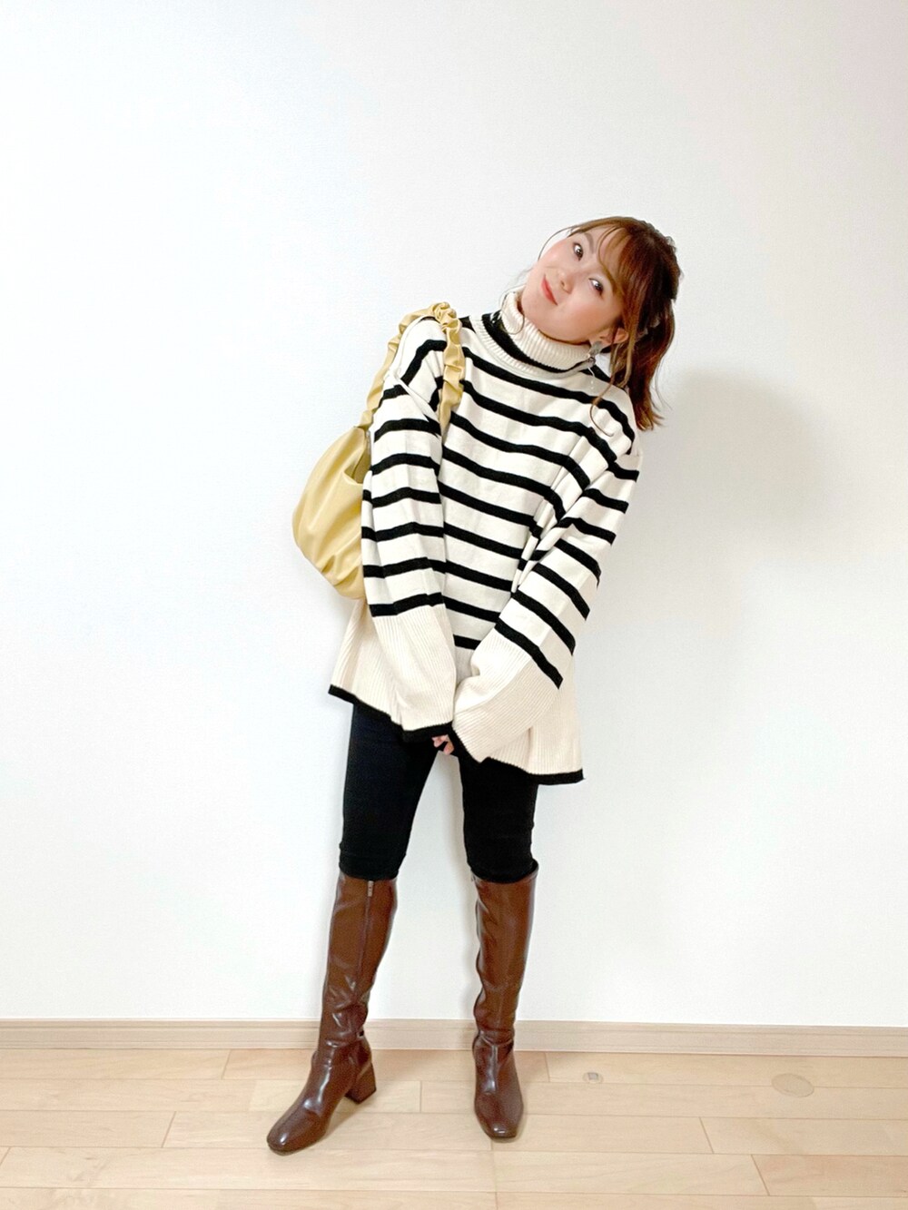 ベージュ系のニット/セーター、ブラック系のその他パンツ、イエロー系のハンドバッグを着用したレディースの冬コーディネートの2枚目の写真