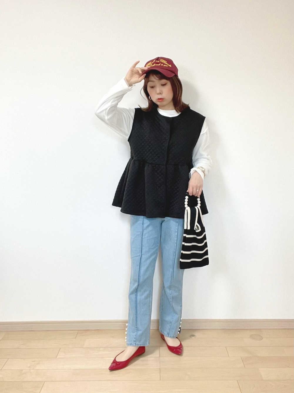 ブラック系のベスト、ブルー系のデニムパンツ、ホワイト系のTシャツ/カットソーを着用したレディースの春コーディネートの5枚目の写真