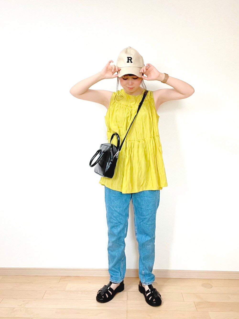 ブラック系のサンダル、イエロー系のシャツ/ブラウス、ブルー系のデニムパンツを着用したレディースの夏コーディネートの2枚目の写真