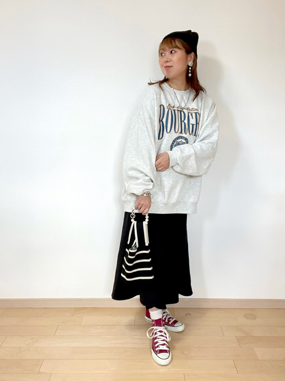 ベージュ系のスウェット、ブラック系のスカート、レッド系のスニーカーを着用したレディースの秋コーディネートの2枚目の写真