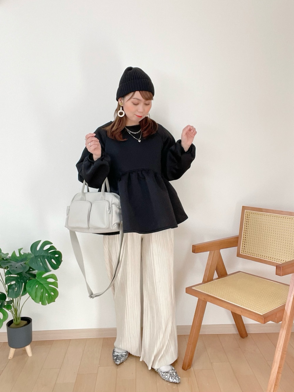 ブラック系のトップス、ホワイト系のその他パンツを着用したレディースの冬コーディネートの3枚目の写真