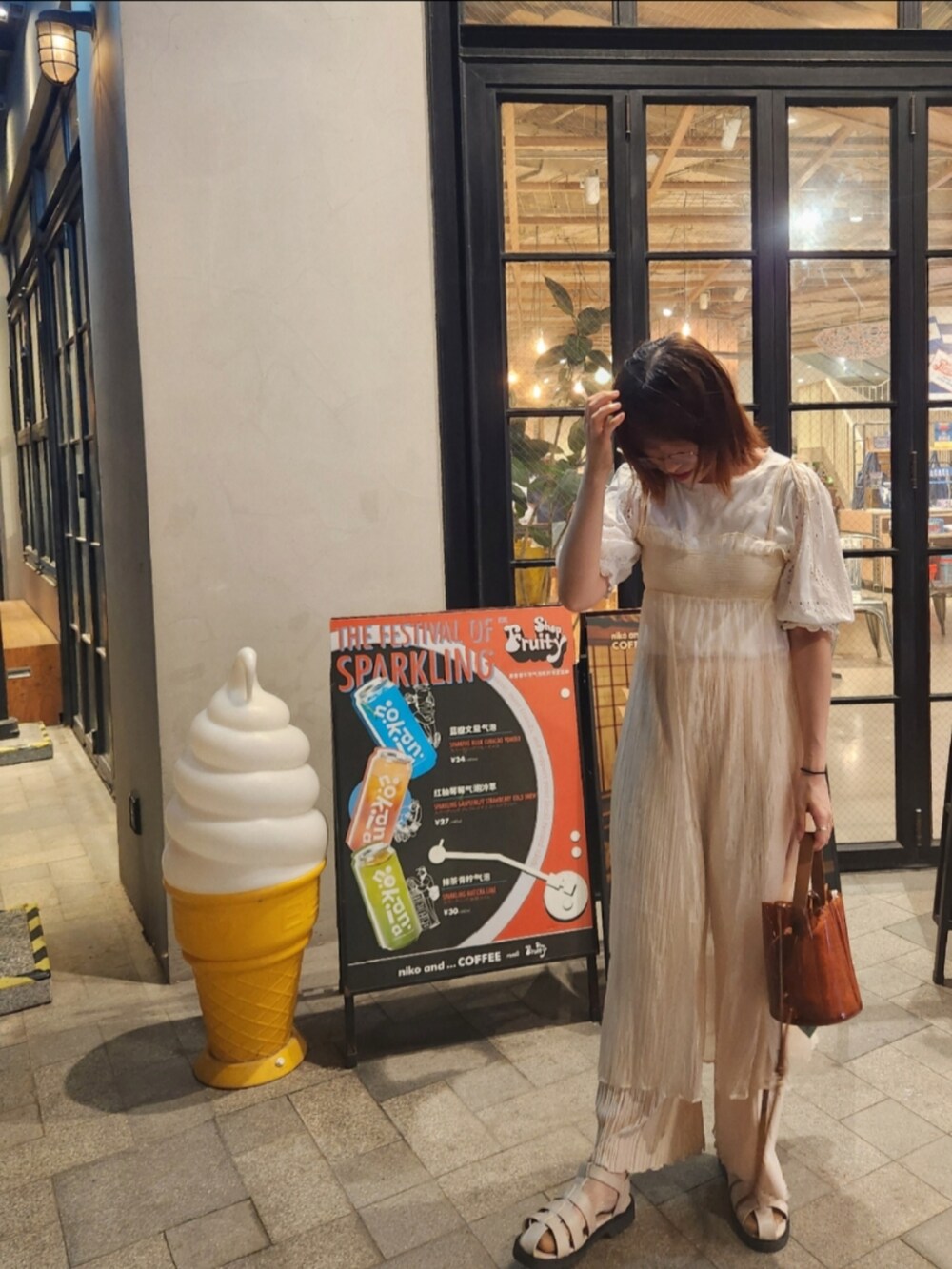 ホワイト系のワンピース、ホワイト系のその他パンツ、ブラウン系のハンドバッグを着用したレディースの夏コーディネートの2枚目の写真