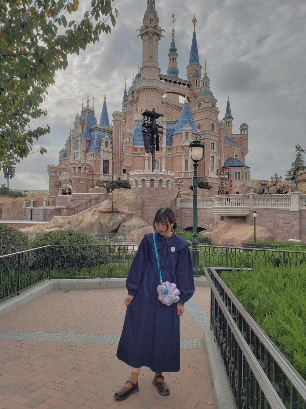 ブルー系のワンピース、ブラウン系のTシャツ/カットソー、イエロー系のショルダーバッグを着用したレディースの秋コーディネートの2枚目の写真