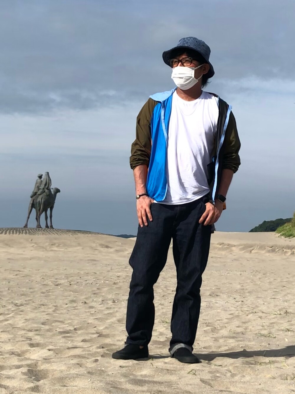 その他のナイロンジャケット、ブルー系のデニムパンツ、ブラック系のスニーカーを着用したメンズの夏コーディネートの2枚目の写真