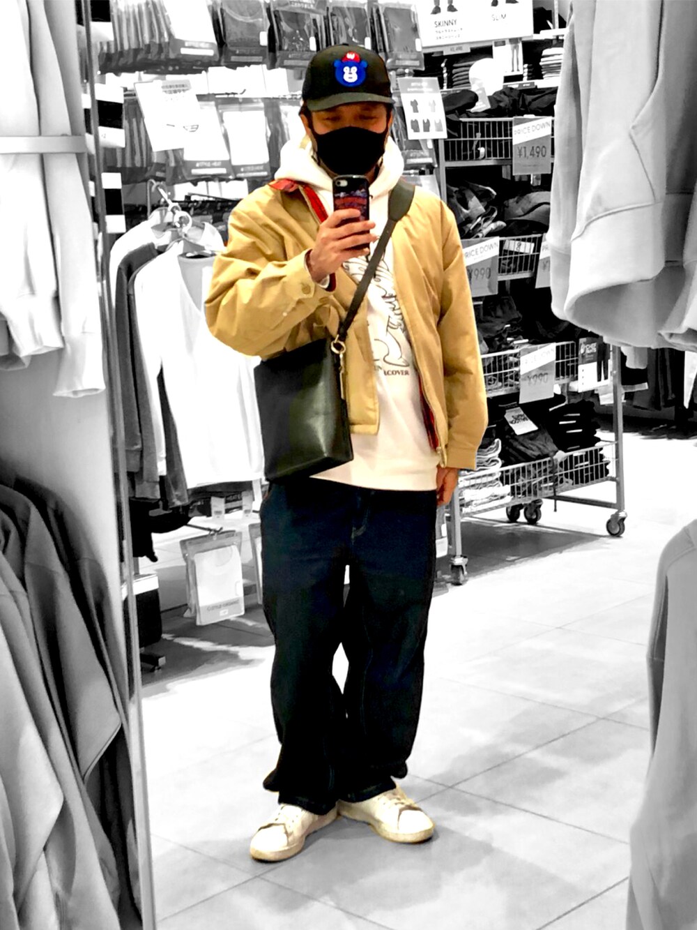 ホワイト系のパーカー、ブラック系のショルダーバッグ、ベージュ系のジャケット/アウターを着用したメンズの冬コーディネートの2枚目の写真