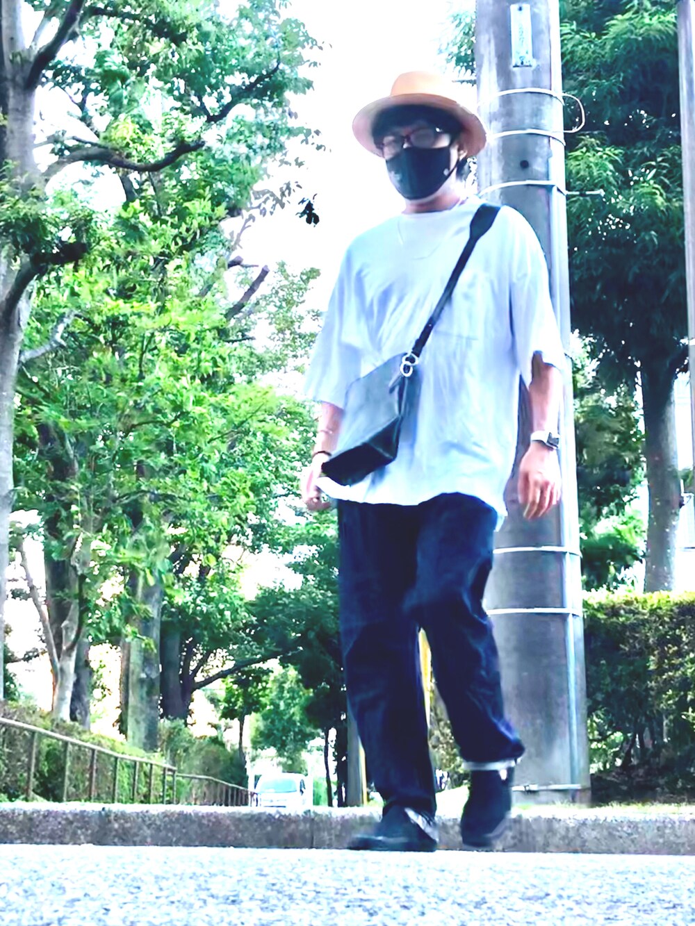 ホワイト系のTシャツ/カットソー、ブラック系のショルダーバッグ、ブルー系のデニムパンツを着用したメンズの夏コーディネートの3枚目の写真
