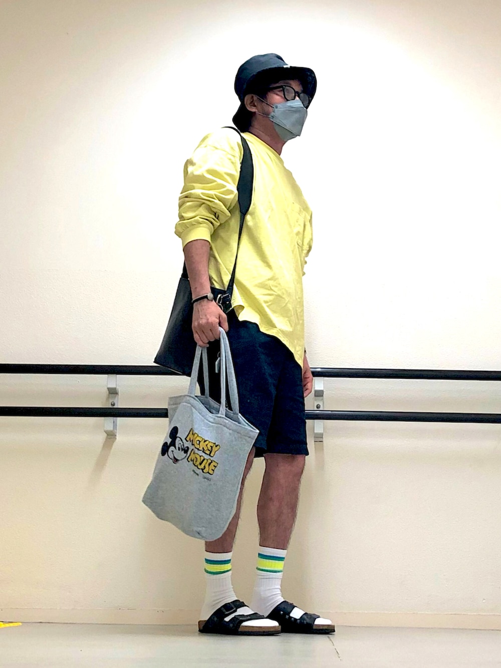 イエロー系のTシャツ/カットソー、ブラック系のショルダーバッグ、ブルー系のデニムパンツを着用したメンズの秋コーディネートの3枚目の写真