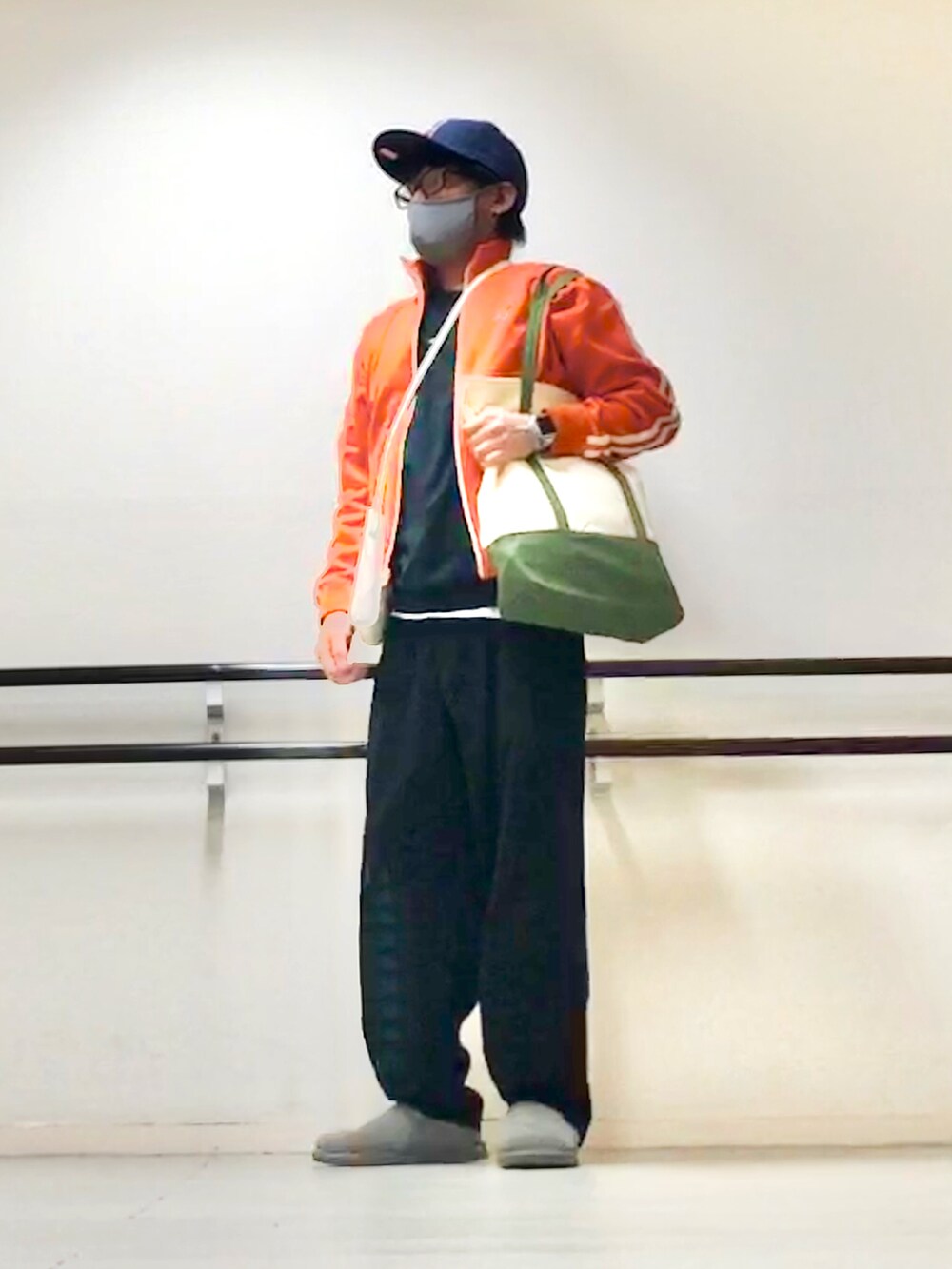 オレンジ系のジャージ、ブラック系のニット/セーター、ブラック系のスウェットパンツを着用したメンズの秋コーディネートの4枚目の写真