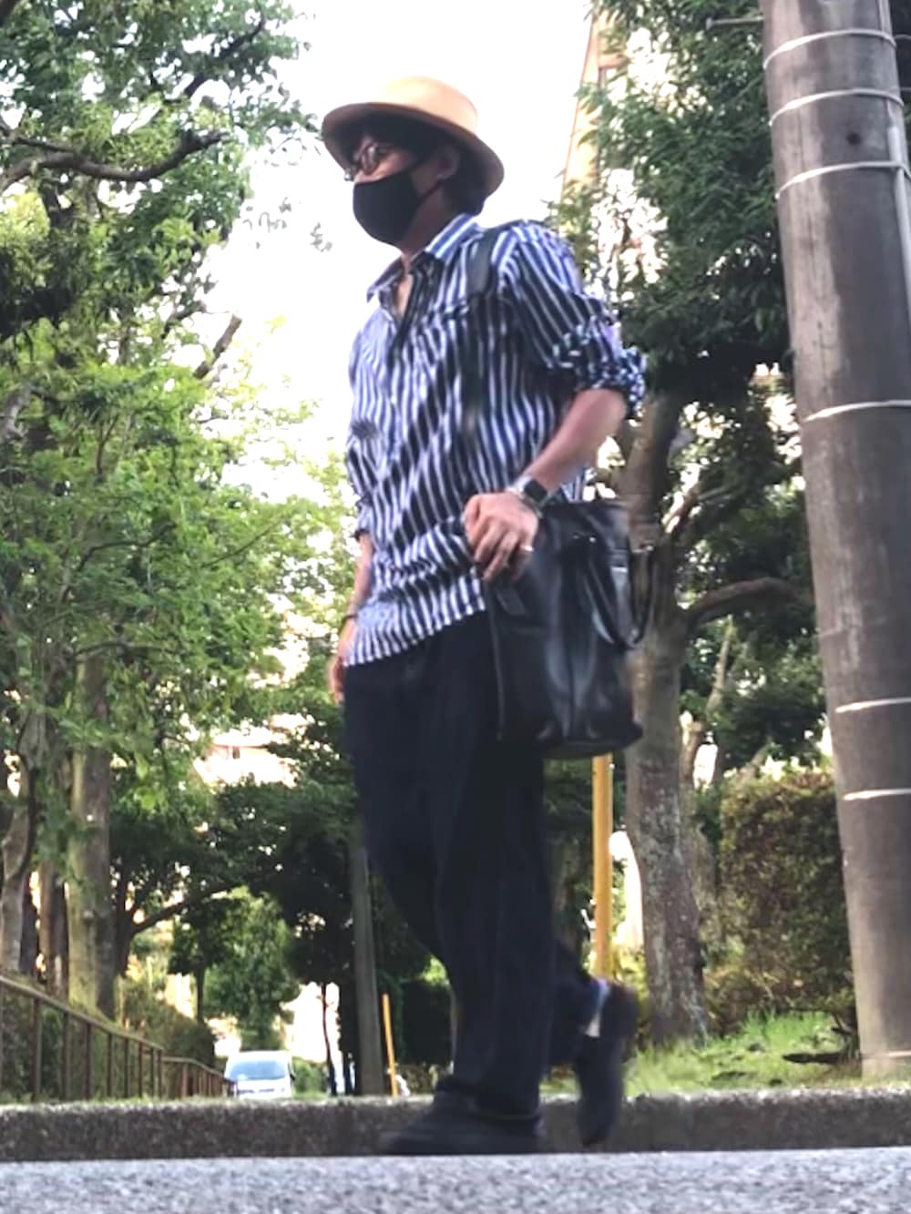ブルー系のシャツ/ブラウス、ブラック系のトートバッグ、ブルー系のデニムパンツを着用したメンズの夏コーディネートの4枚目の写真