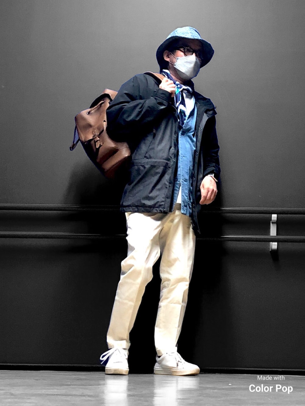 ブラック系のマウンテンパーカー、ブルー系のカーディガン/ボレロ、ブラウン系のバックパック/リュックを着用したメンズの春コーディネートの2枚目の写真