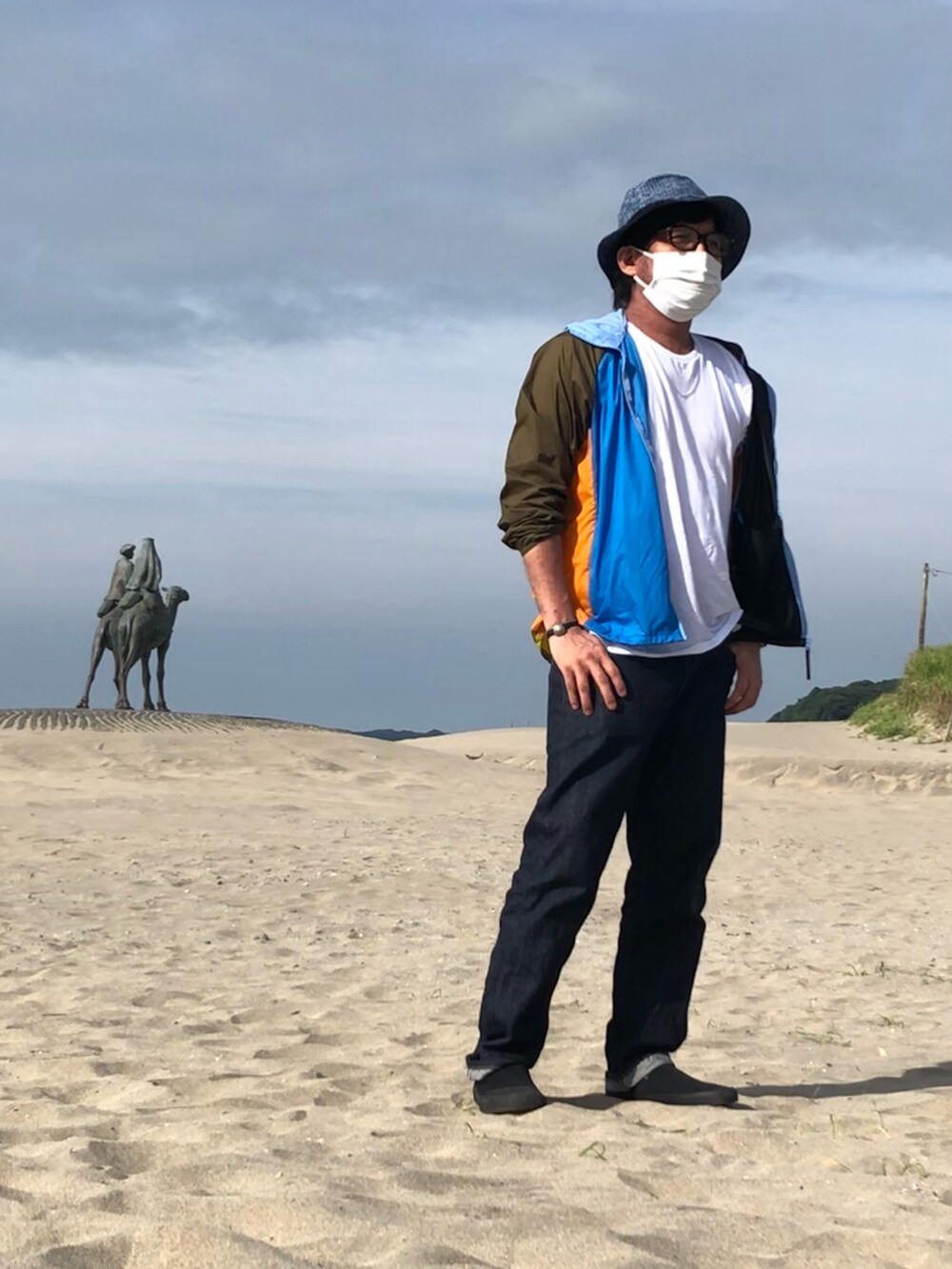 その他のナイロンジャケット、ブルー系のデニムパンツ、ブラック系のスニーカーを着用したメンズの夏コーディネートの4枚目の写真