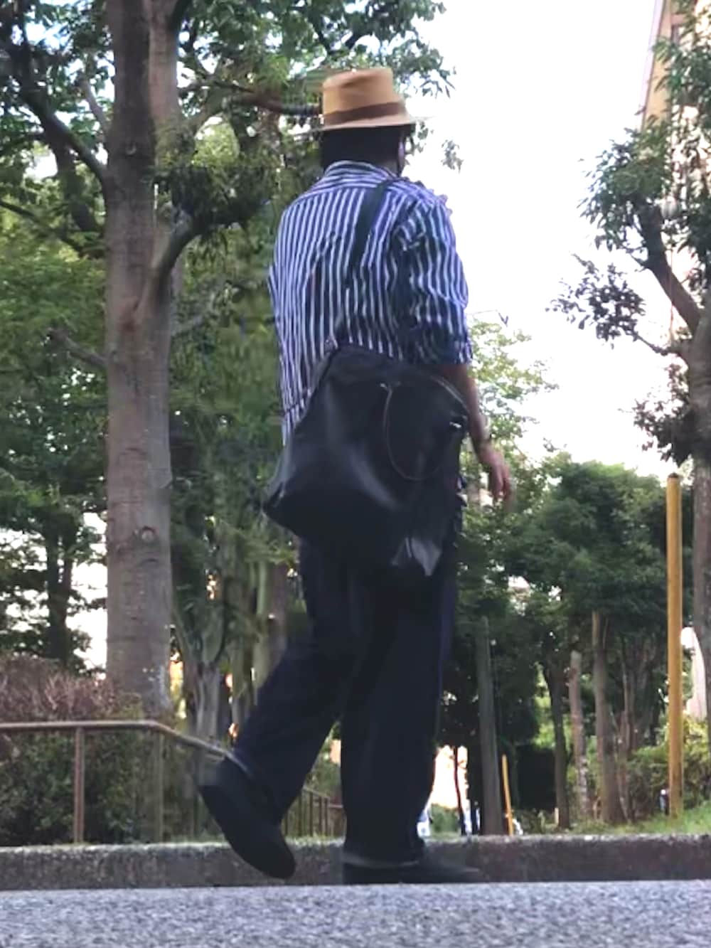 ブルー系のシャツ/ブラウス、ブラック系のトートバッグ、ブルー系のデニムパンツを着用したメンズの夏コーディネートの3枚目の写真