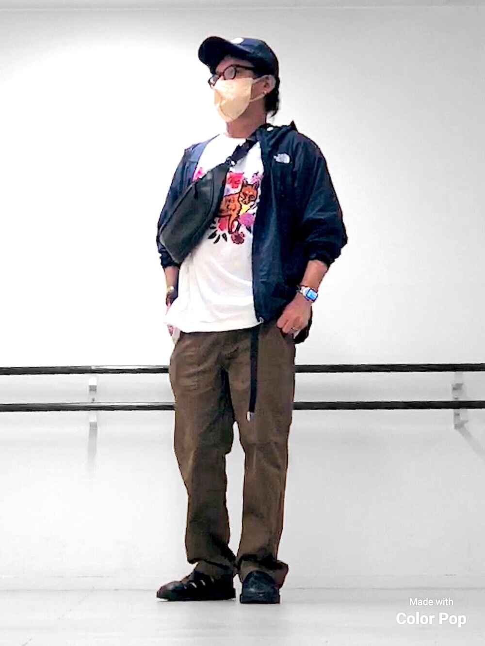 ブルー系のマウンテンパーカー、ホワイト系のTシャツ/カットソー、ブラック系のボディバッグ/ウエストポーチを着用したメンズの秋コーディネートの2枚目の写真