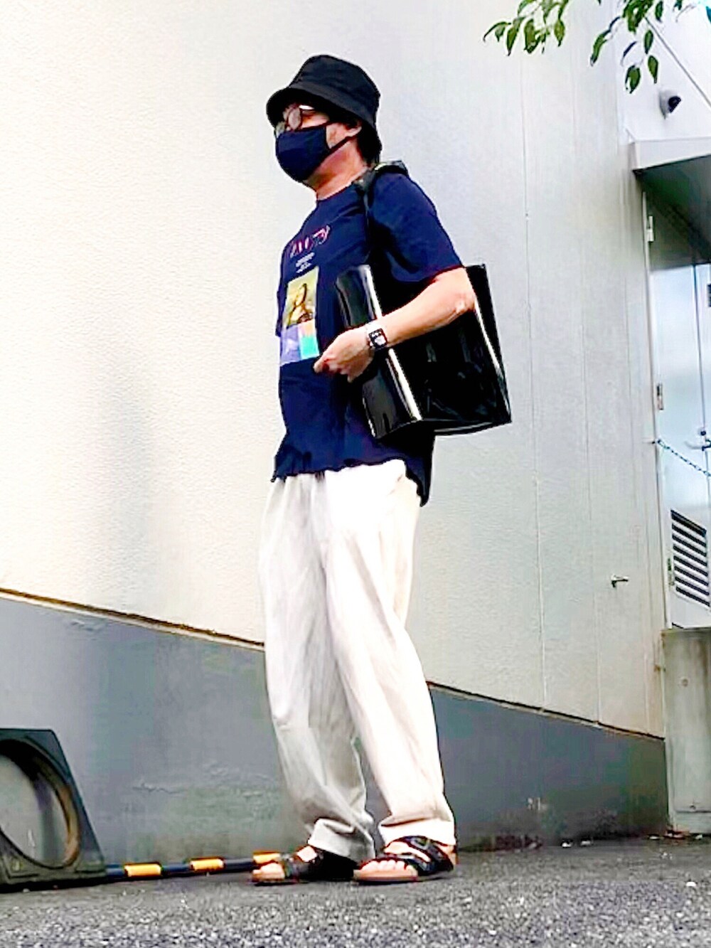 ブルー系のTシャツ/カットソー、ブラック系のトートバッグ、ベージュ系のスウェットパンツを着用したメンズの夏コーディネートの3枚目の写真