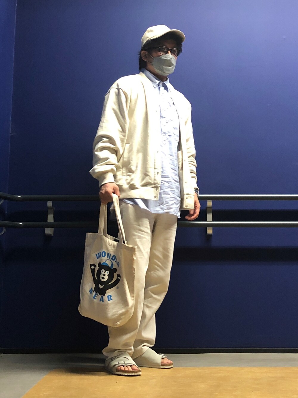 ベージュ系のスウェット、ブルー系のシャツ/ブラウス、ホワイト系のデニムパンツを着用したメンズの春コーディネートの5枚目の写真