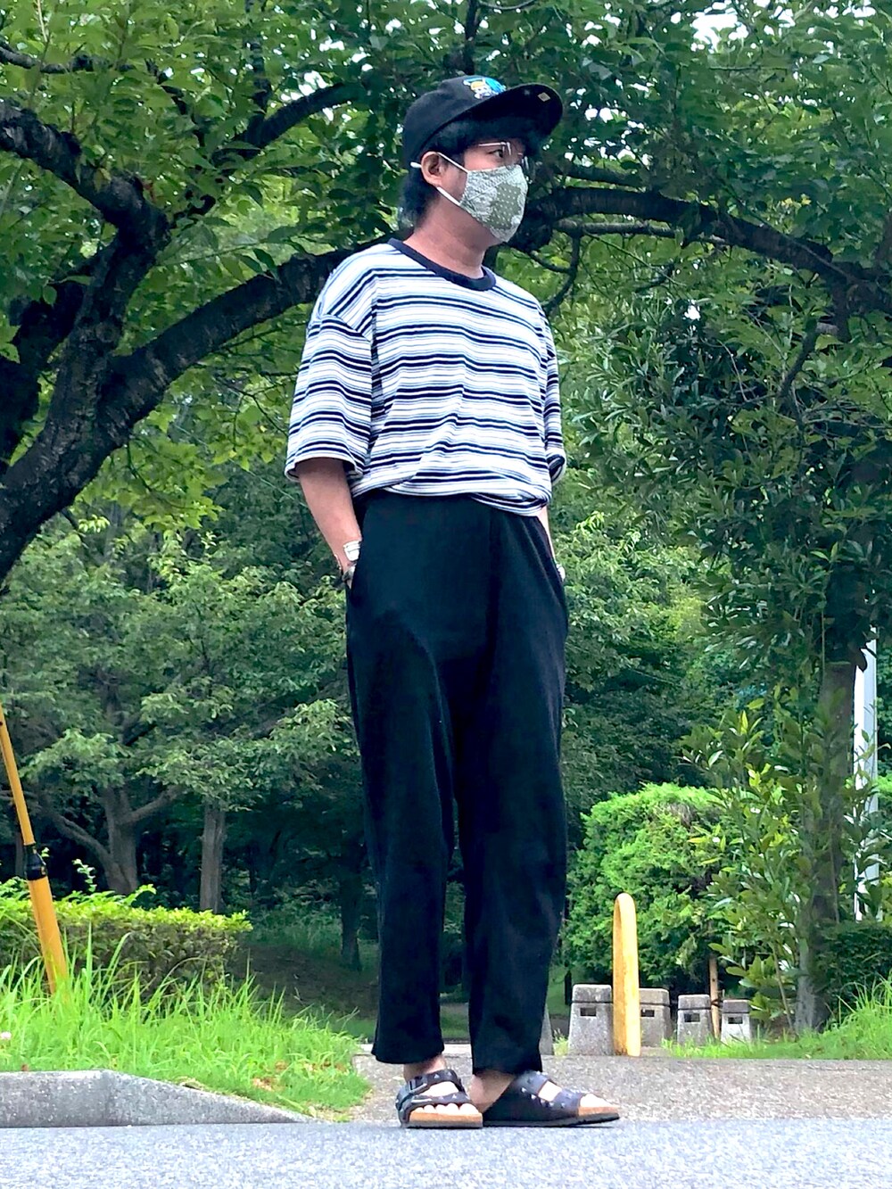 ブルー系のTシャツ/カットソー、ブラック系のスウェットパンツ、ブラック系のサンダルを着用したメンズの秋コーディネートの2枚目の写真